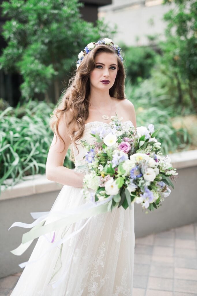 A bride holds a boquet with pastel accents