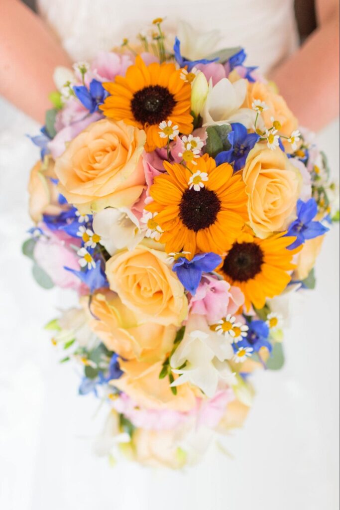 A bridal bouquet full of yellow and blue blossoms