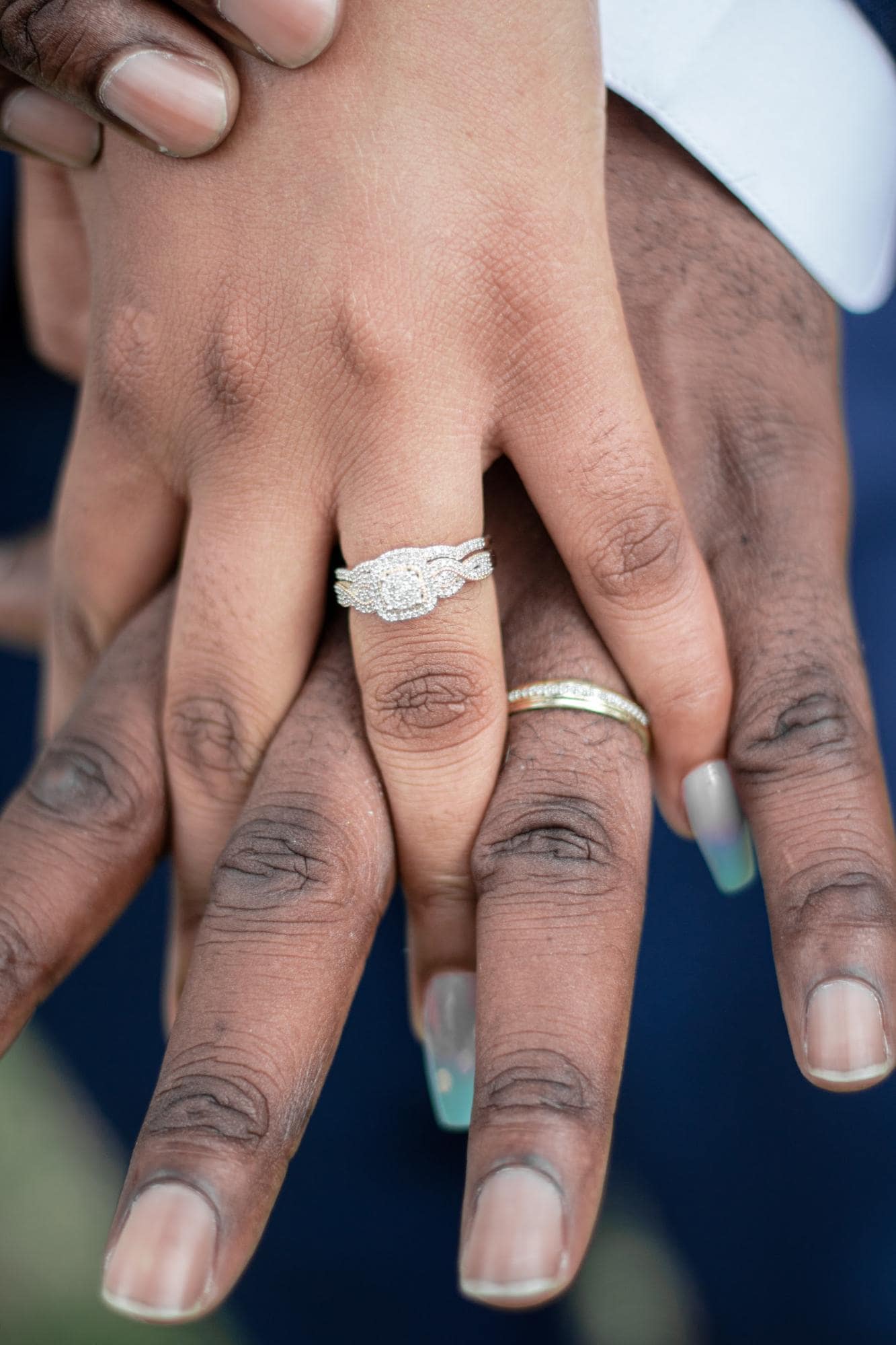 hands of a couple wearing a vintage engagement ring design