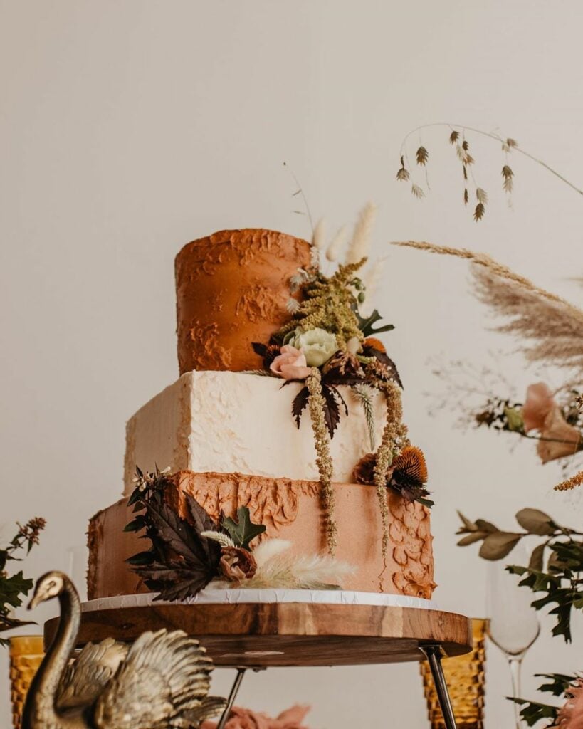 Tiered earthy wedding cake sitting on a cake stand