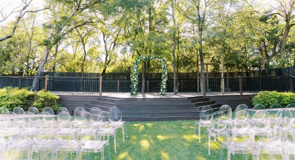 A grassy outdoor ceremony space surrounded by trees at Dallas Oasis