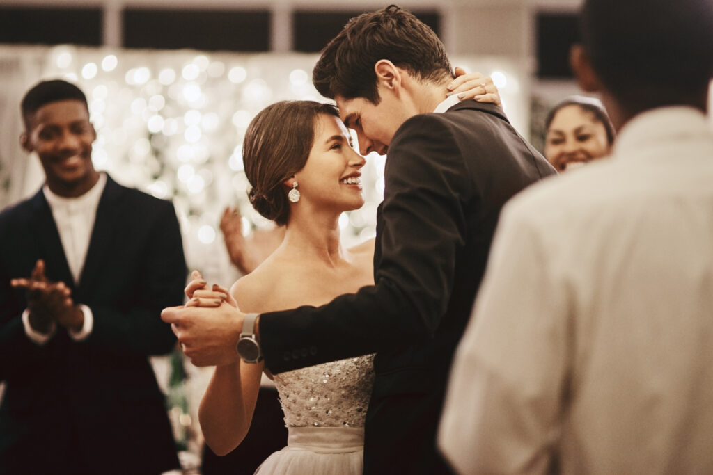 A newly married couple happily taking their first dance on the dance floor