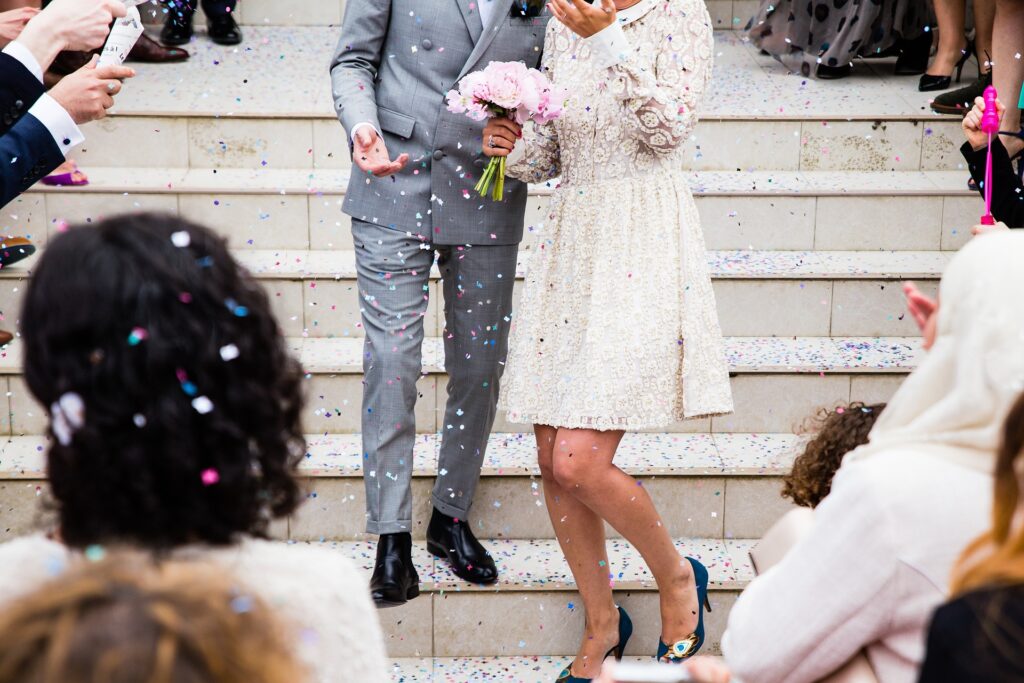 A newlywed couple is congratulated as they descend the stairs after their ceremony