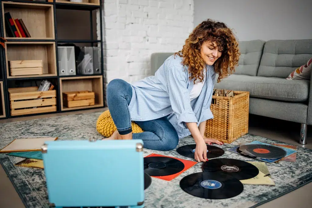 A bridesmaid places a personalized vinyl record into her record player