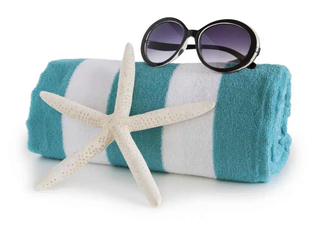 An embroidered beach towel, sunglasses, and sun-dried starfish for a bridesmaid gift