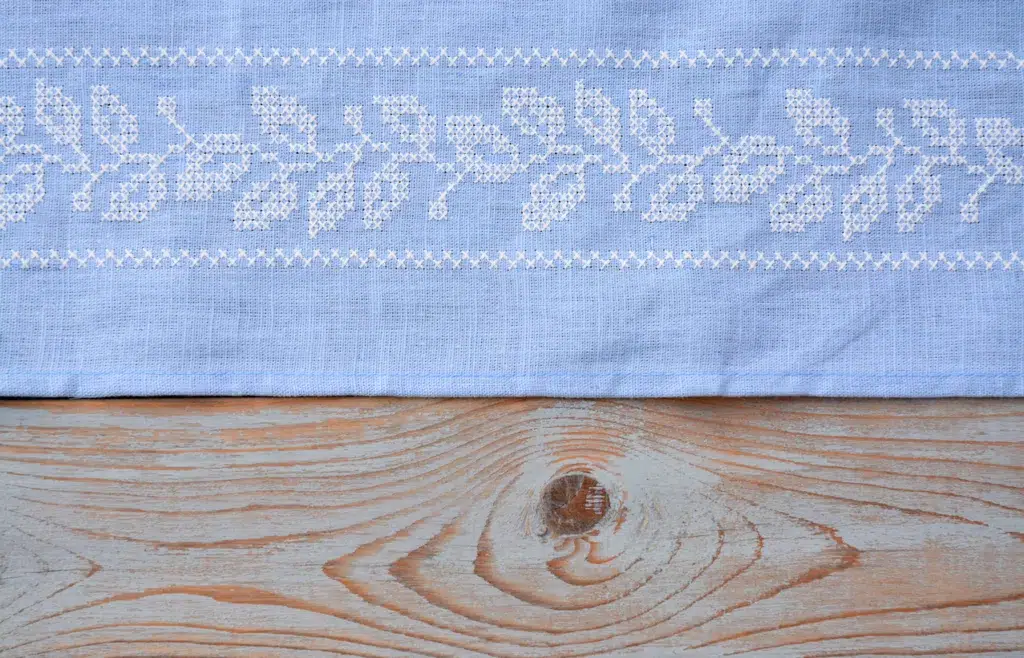 Background of empty embroidery tea towel on rustic wooden table