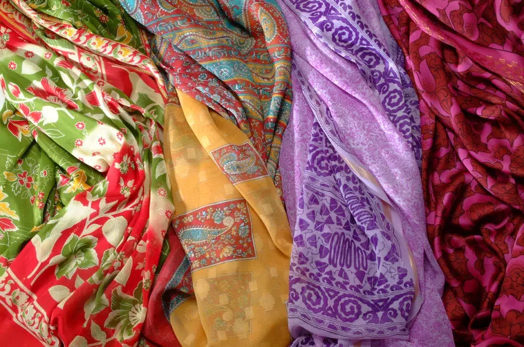 Several hand-painted scarves laid out in a row