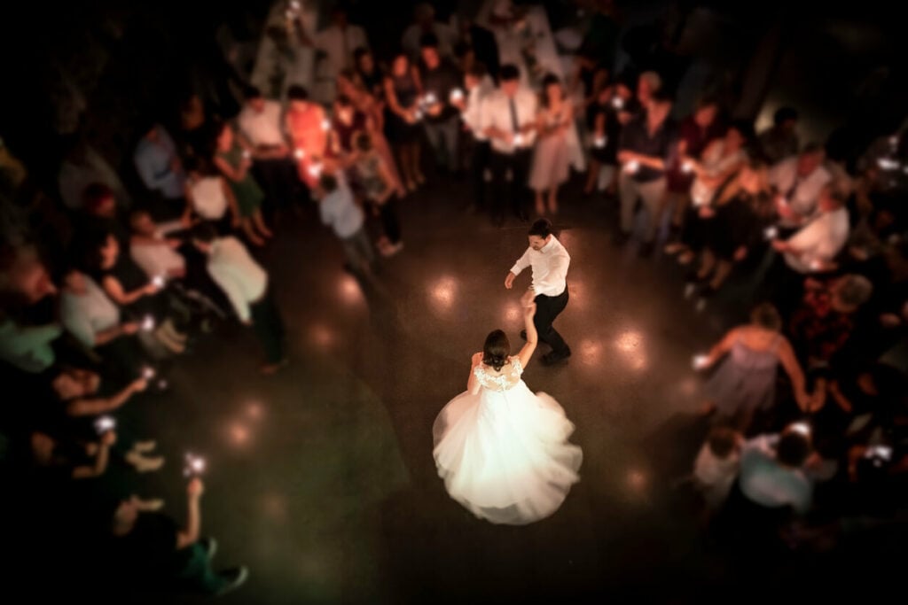 The bride and groom participate in the last dance surrounded by friends and family