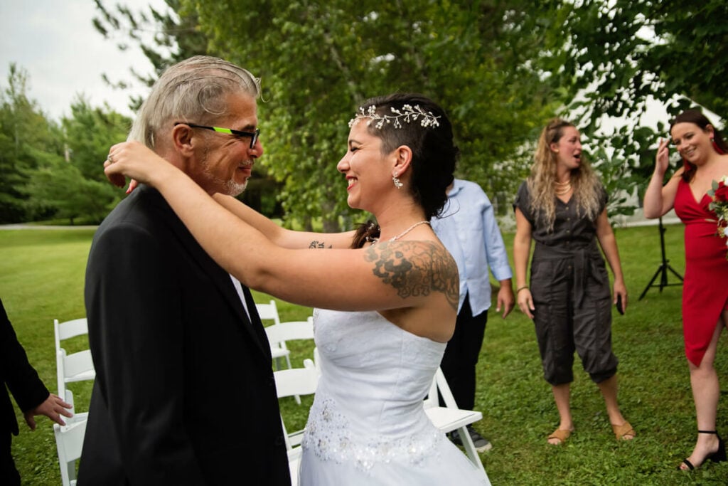 A father and daughter begin to dance to their father-daughter dance song.